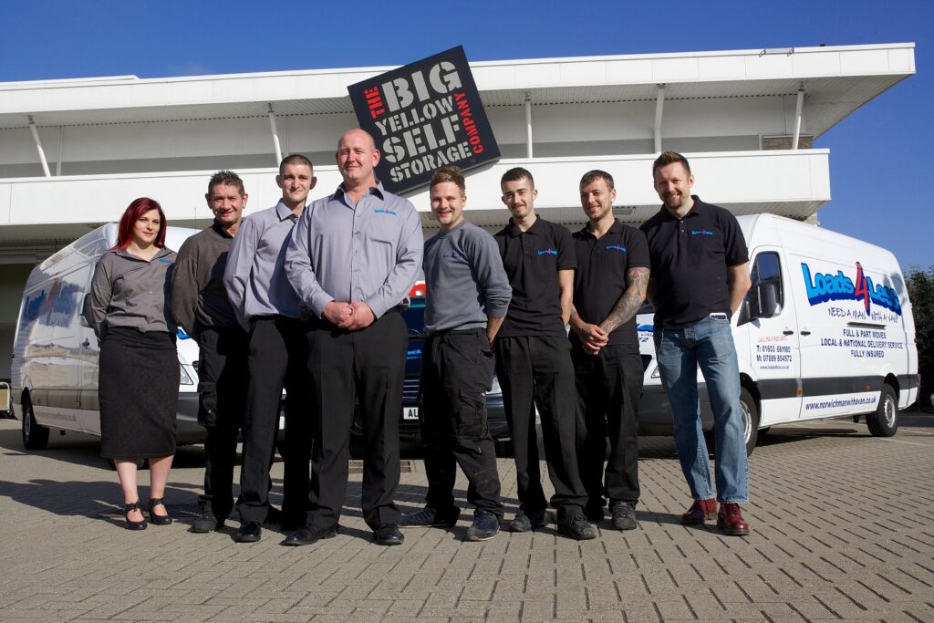 The loads4less staff members standing in front of fleet vehicles.