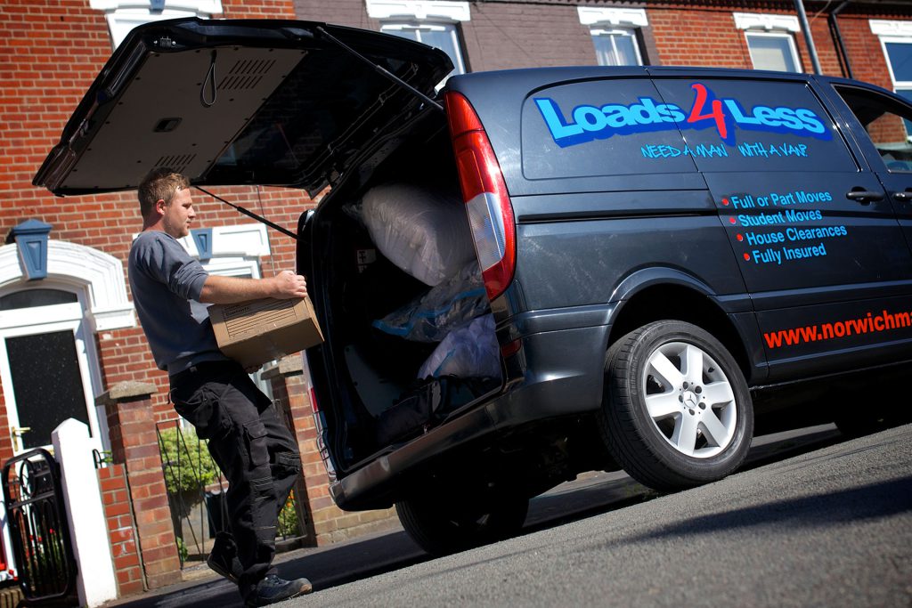 Man with a van in Norwich lifting boxes into van.